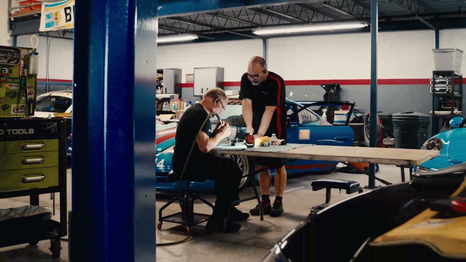 Vortex technicians working beside a blue Porsche race car
